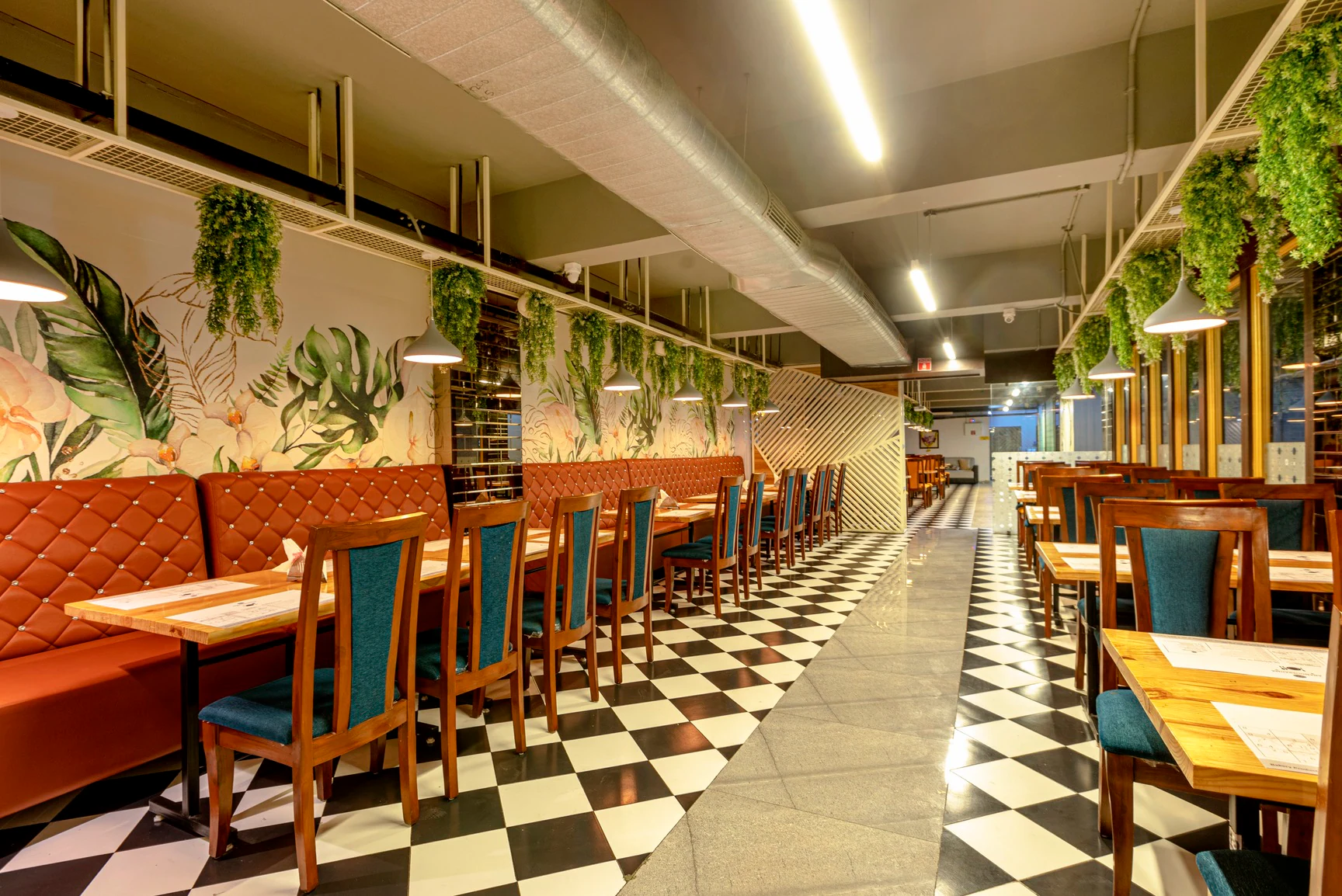 Anandobrahma restaurant interior with warm lighting and floral murals